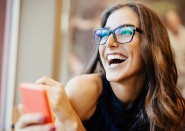 Young woman with glasses smiling and laughing